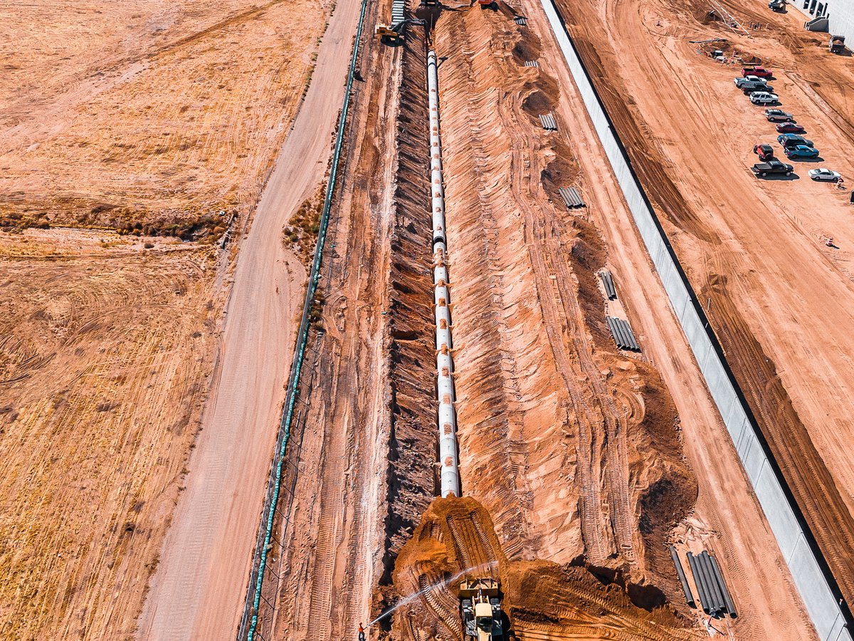 Jensen RCP pipe staged alongside open trench with excavators on active jobsite