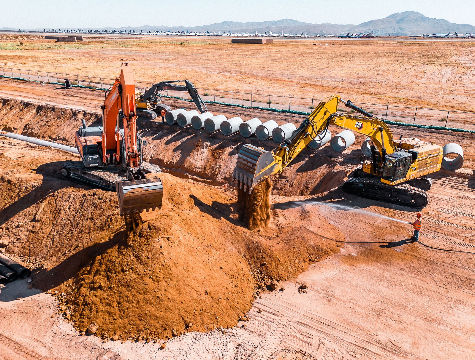 Excavators working alongside staged Jensen RCP pipe
